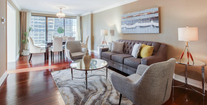 Living and dining area staged for a home sale with white and grey furnitures by StyleBite Staging in Toronto.