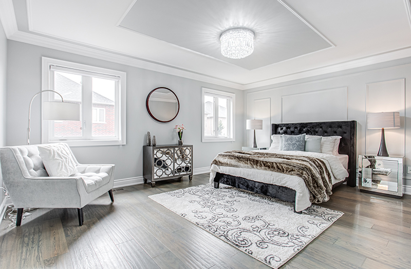 White bedroom staged with black headboard and mirrored furnitures by StyleBite condo and home staging services in Toronto
