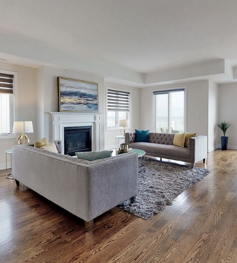 Living room with access to terrace and windows with grey and gold decor after StyleBite home staging services in Toronto