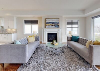 Open floor plan living room staged with grey rugs and furnitures by StyleBite home staging services in Toronto.