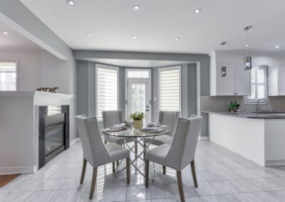 Kitchen with fireplace staged with crystal table and grey chairs by StyleBite home staging services in Toronto.