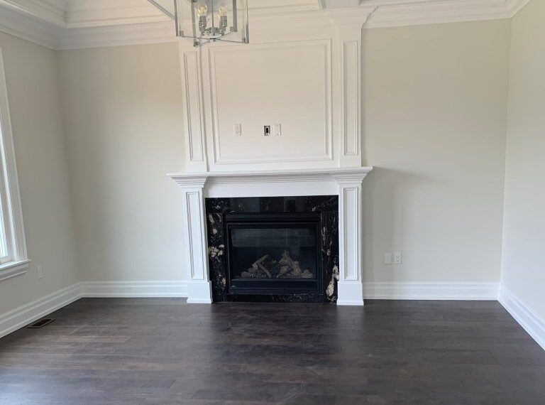 White living room with windows and wood fireplace before staging by StyleBite home staging services in Toronto.
