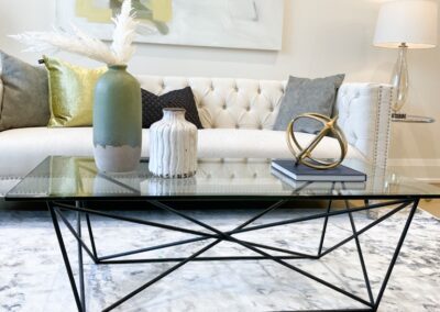 Living area with white couch staged with crystal table and gold decor by StyleBite home staging services in Toronto.