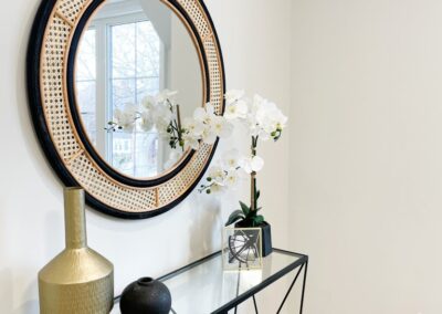 Entrance staged with round mirror and flower with a crystal table by StyleBite home staging services in Toronto.