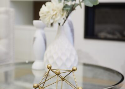 Stage of a round crystal table with white vasel and gold decor by StyleBite home staging services in Toronto.