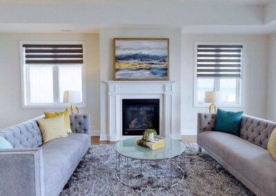 Living room with windows staged with grey rugs and furniture by StyleBite home staging services in Toronto.