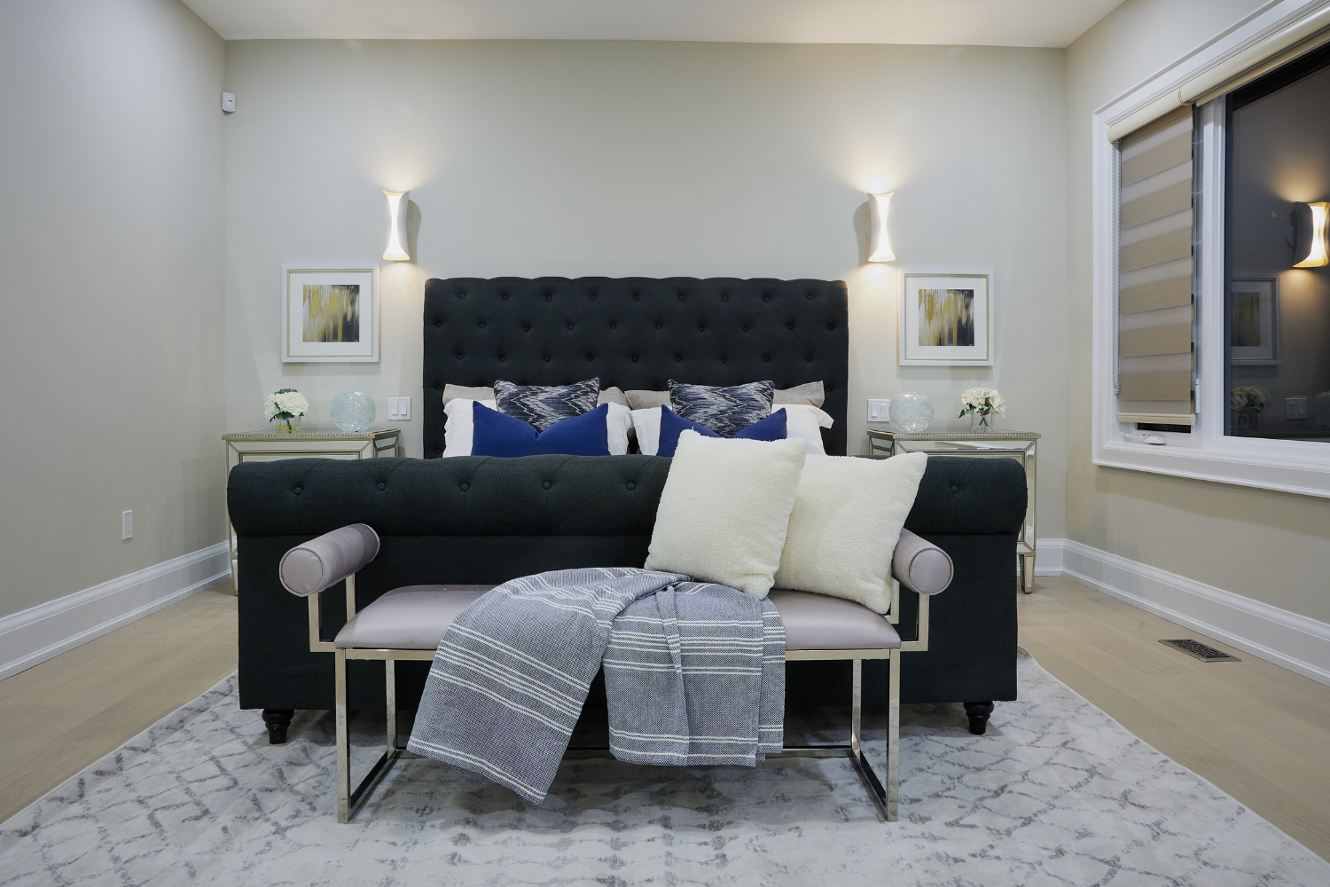 All white bedroom condo with a black headboard, two side beds and lamps, and blue decor by Style Bite Staging in Toronto.