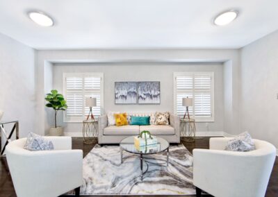 Living room with beige and white furnitures, with windows and colorful decoration by StyleBite home staging services in Toronto.