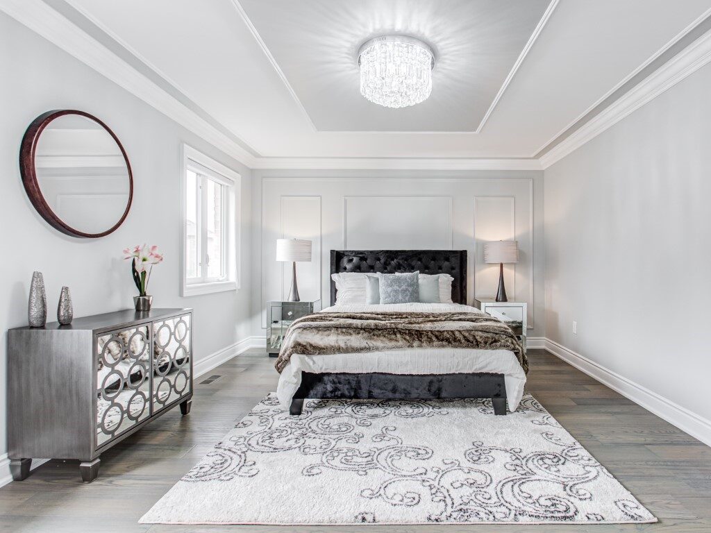 Bedroom staged with black headboard and mirrored furnitures by StyleBite home staging services in Toronto.