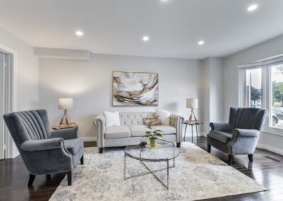 White living room with view staged with grey chairs and beige couch by StyleBite home staging services in Toronto.