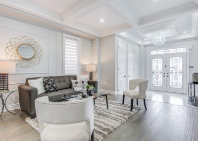 Living room in front of main entrance staged with white and grey furnitures by StyleBite home staging services in Toronto.